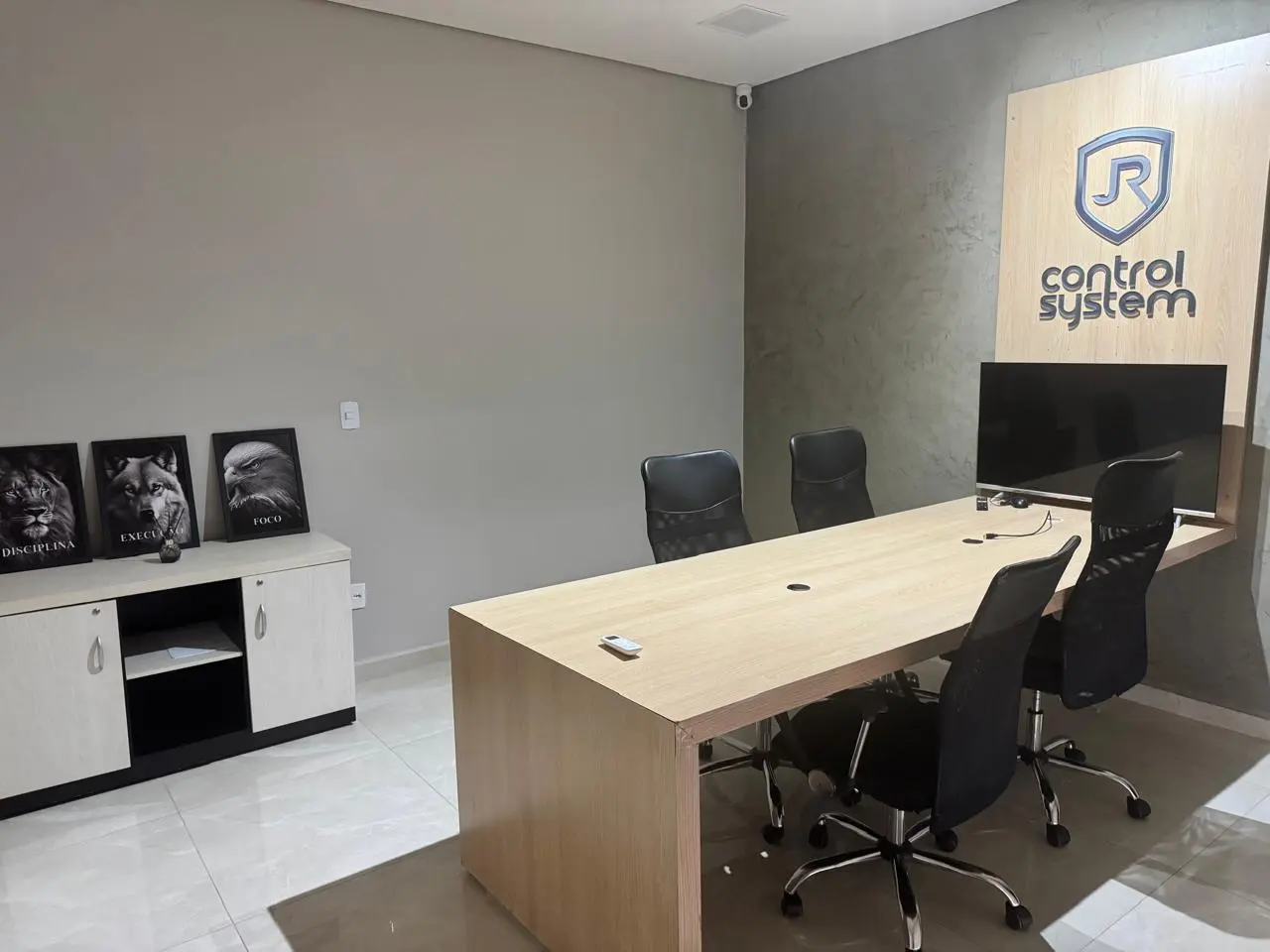 Sala de reunião da JR Control System com identidade visual da empresa